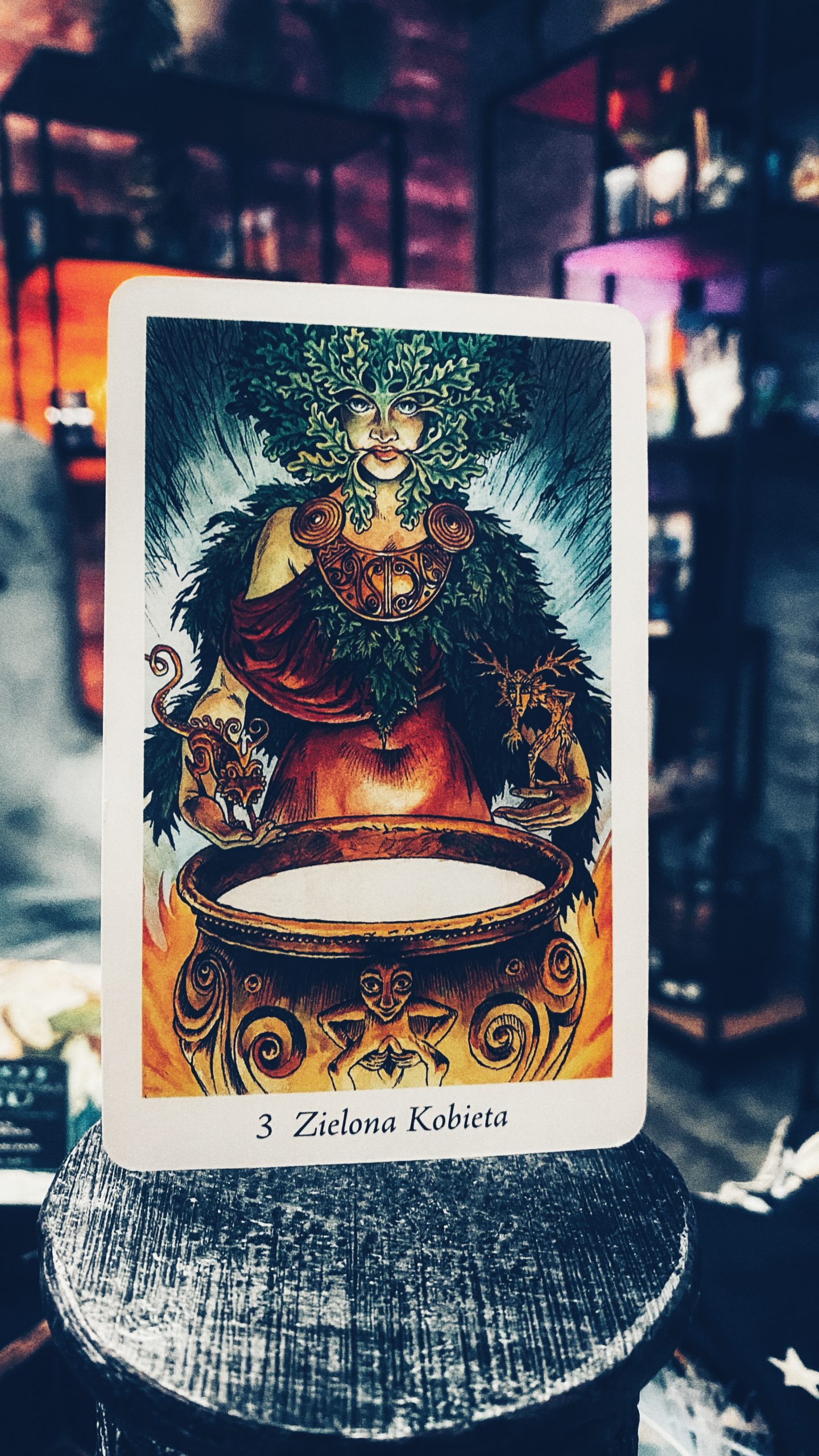 Karta Zielona Kobieta z talii tarota, symbolizująca naturę i płodność, na tle mistycznego wnętrza, idealna do interpretacji drogi życia i kart życia tarot.